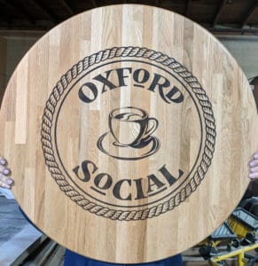 custom logo for oxford social on natural oak butcher block top