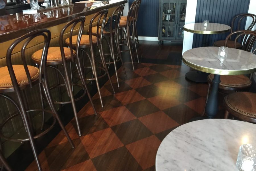 brass banded marble table tops paired with victorian bases, in Slay Steak + Fish House